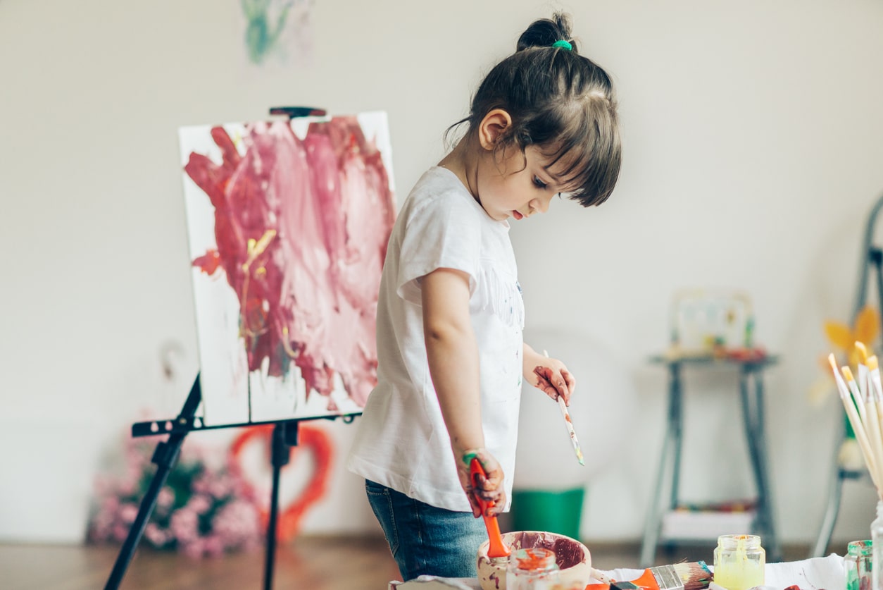 Cut girl painting in at her home.